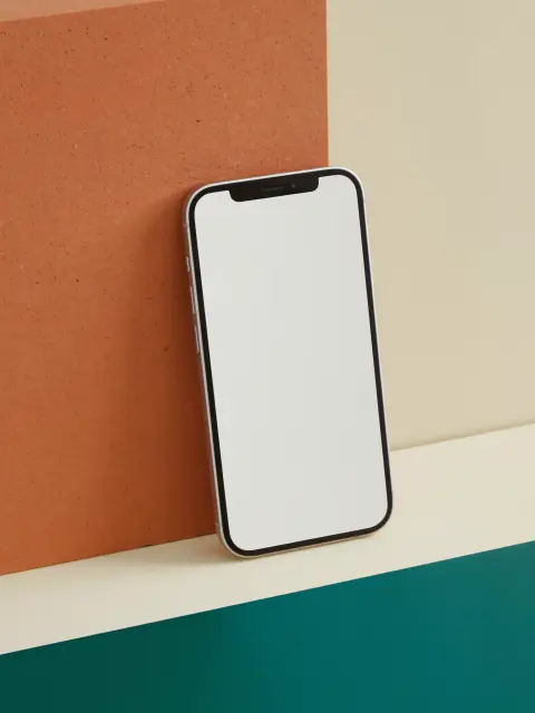 Still life: celular apoiado em blocos creme e teal